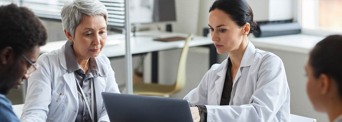 doctors in a meeting looking at a laptop screen